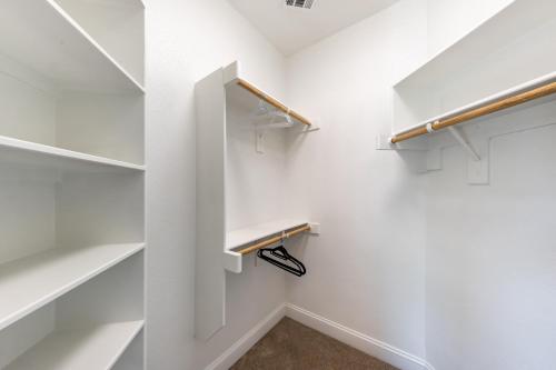 a walk in closet with white shelves at Family Home Near Lake & Local Parks in Little Elm