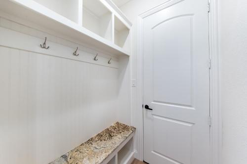 a walk in closet with a white door and a bench at Family Home Near Lake & Local Parks in Little Elm