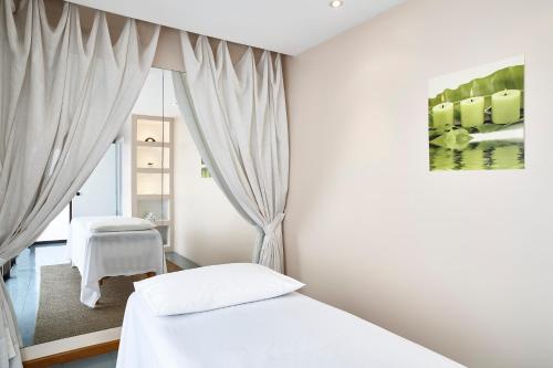 サンパウロにあるGeorge V Casa Brancaの白いベッドルーム(ベッド2台、窓付)