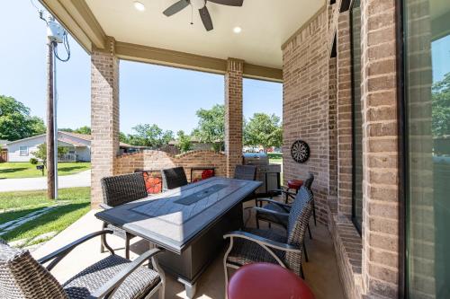 a patio with a table and chairs and a fireplace at Family Home Near Lake & Local Parks in Little Elm