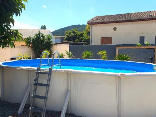 une échelle se trouve à côté d'une grande piscine dans l'établissement Villa climatisée avec piscine proche des plages, à La Crau