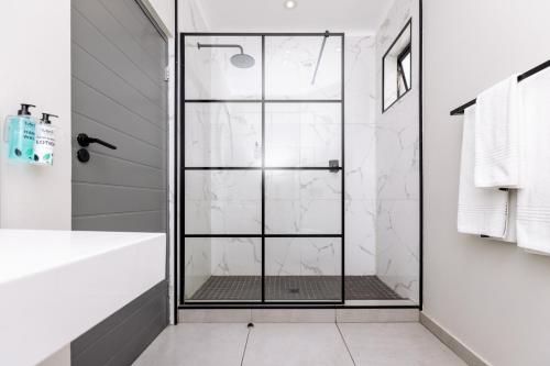 a shower with a glass door in a bathroom at MINT Hotel 84 on Katherine in Johannesburg