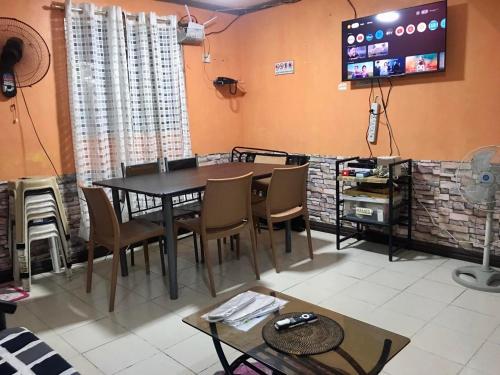 a dining room with a table and chairs and a tv at 1 AC BR House 400mbps, Netflix,Parking,Massager,Cook in Rodriguez