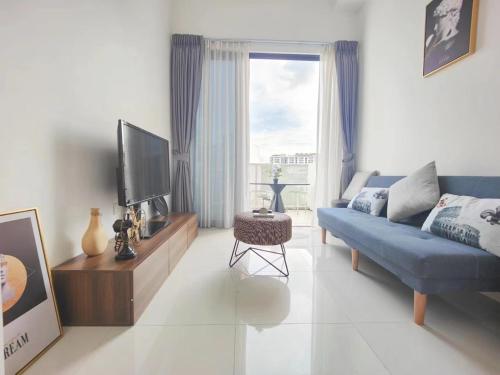 een woonkamer met een blauwe bank en een tv bij Centralize Stylish Loft Apartment Beside Mrt 摩登小屋 in Singapore