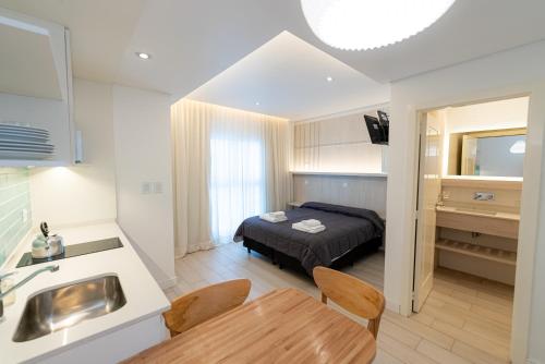 1 dormitorio con 1 cama y cocina con mesa en Hotel Fatun en Mar del Plata