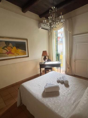 a bedroom with a bed with two towels and a piano at Maison Barriera - Luxury Suites - Salerno City Center in Salerno