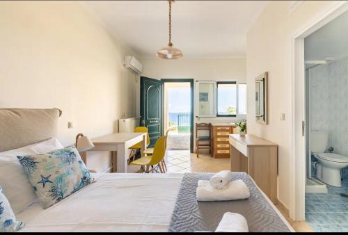 een slaapkamer met een bed en een bureau en een badkamer bij Villa Dimitra - Amazing sea view in Póros