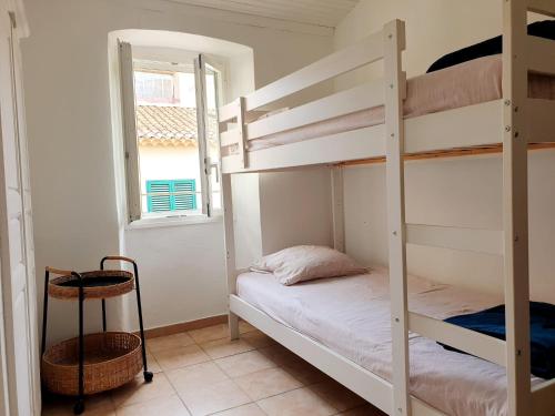 une chambre avec deux lits superposés et une fenêtre dans l'établissement Appartement à 2 mn a pied de la plage L'Ile Rousse Corse, à LʼÎle-Rousse
