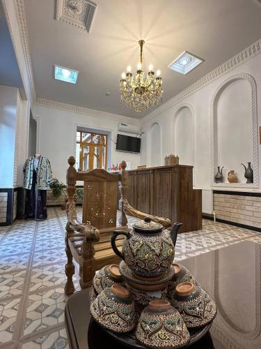 sala de estar con lámpara de araña y tetera en MUNIS Hotel lyabi houz, en Bukhara