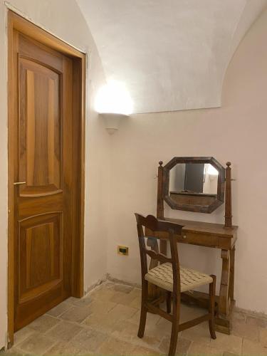 a room with a wooden table and a chair and a mirror at Il Giardinetto di Pettorano in Pettorano sul Gizio