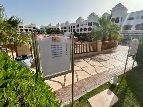 a sign in front of a building with palm trees at Fun & Sun Naama Waves in Sharm El Sheikh