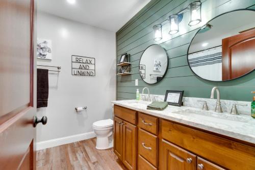 a bathroom with a sink and a toilet and mirrors at Scenic Yankton Retreat with Fire Pit 1 Mi to Lake! in Yankton