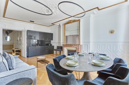 une salle à manger avec une table, des chaises et un canapé dans l'établissement Sublime Apartment Montaigne Arc de Triomphe by Studioprestige, à Paris