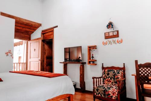 a bedroom with a bed and a chair at Hotel Casa Alquimia in Quito