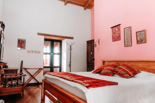 a bedroom with a white bed with red pillows at Hotel Casa Alquimia in Quito