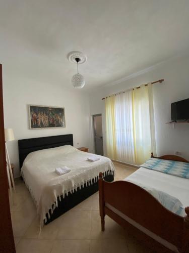 1 dormitorio con 2 camas y TV. en Selami GuestHouse, en Peshkopi