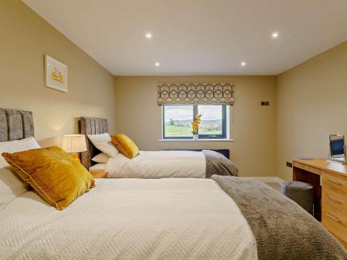 a bedroom with two beds and a window at 4 Bed in Shap 89957 in Shap