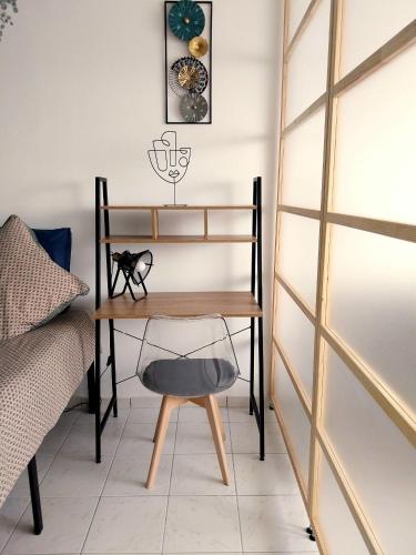 un bureau avec une chaise à côté d'un lit dans l'établissement Studio lumineux 3 min Gare Houilles - RER A, Ligne L et J, à Houilles