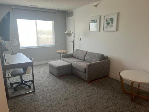 a living room with a couch and a desk at TownePlace Suites Detroit Warren in Warren