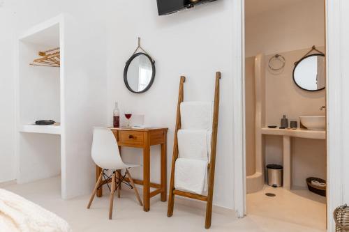 a bedroom with a desk and a chair and a table at Naxos Beachwalk Rooms in Naxos Chora