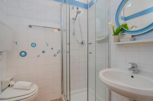 uma casa de banho com um chuveiro, um WC e um lavatório. em Hotel Mia em Rimini
