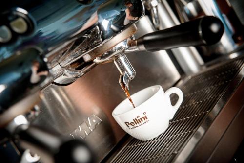 a coffee maker is pouring coffee into a cup at Casa Hellen in Monteforte dʼAlpone