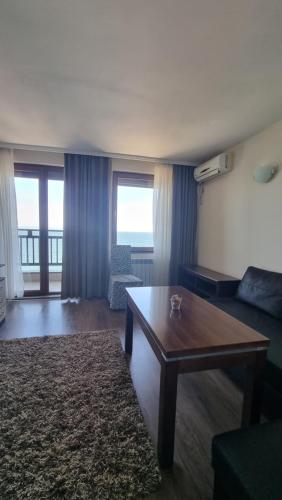hotel DIAMANTI في سوزوبول: غرفة معيشة مع طاولة وأريكة