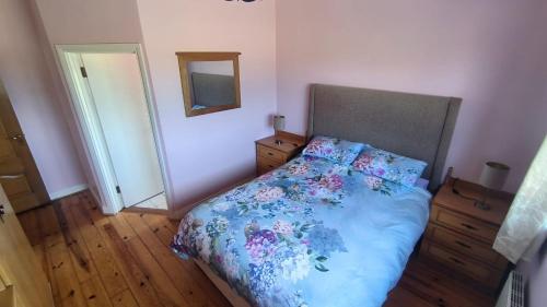een slaapkamer met een bed met een blauw dekbed en een spiegel bij Swinford Country House in Swinford