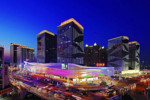 Wind sleeping Color Hotel - GuangZhou CHIME LONG Line7&18Nancun Wanbo STN في قوانغتشو: أفق المدينة مع المباني الطويلة والزحمة في الليل