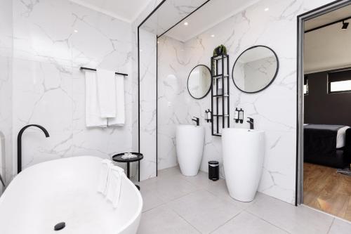 a bathroom with two sinks and two mirrors at MINT Hotel 84 on Katherine in Johannesburg