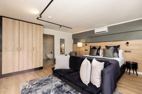 a bedroom with a large bed and a couch at MINT Hotel 84 on Katherine in Johannesburg