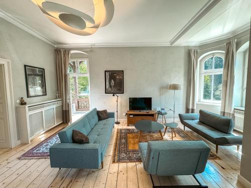 緬濟古熱的住宿－Villa Klara - Apartamenty Wakacyjne，客厅配有蓝色的沙发和椅子
