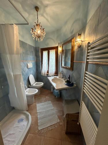 a bathroom with a sink and a toilet and a chandelier at appartamento storico Valle San Martino di Spoleto in Spoleto