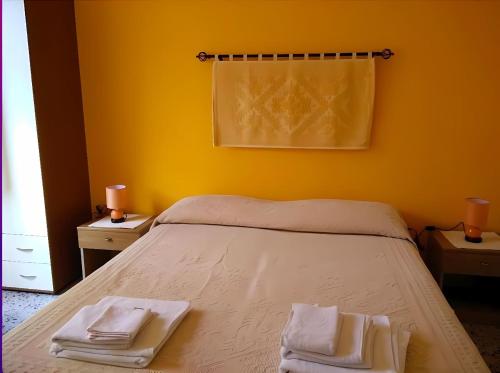 ein Schlafzimmer mit einem Bett mit zwei Handtüchern darauf in der Unterkunft BB Le Violette in Tortolì