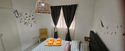 a bedroom with a bed with two orange pillows on it at Nuestra Recova en Pilar BsAs in Pilar