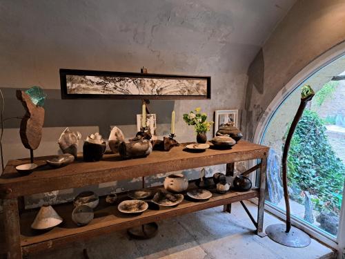 uma exibição de cerâmica numa prateleira num quarto em Le Mas du Lac em Uzès