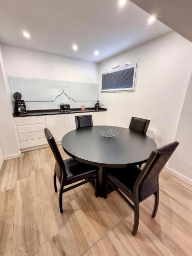 une salle à manger avec une table et des chaises noires dans l'établissement Mont Gîte Des Herbus Salicorne 6personnes entre Granville et Mont Saint Michel, à Vains