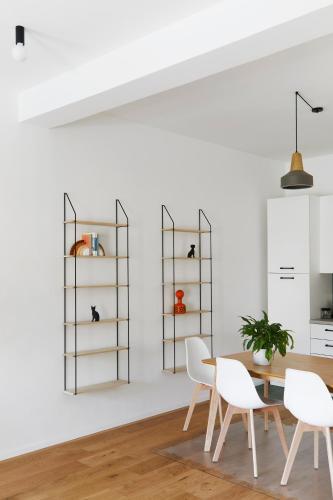 a dining room with white chairs and a table and shelves at La Sismonda in Rimini