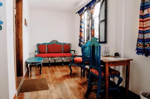 a living room with a red couch and a table at Hotel Casa Alquimia in Quito