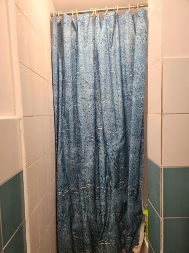 łazienka z prysznicem z niebieską zasłoną prysznicową w obiekcie Hostel Warszawa Ursynów w Warszawie