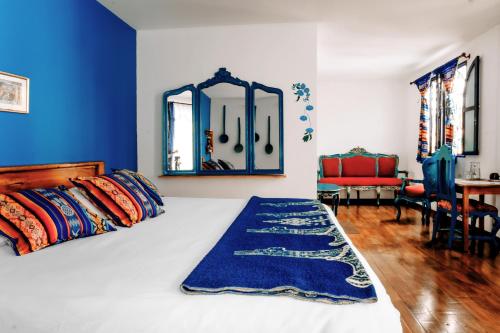 a bedroom with a bed with a blue wall at Hotel Casa Alquimia in Quito