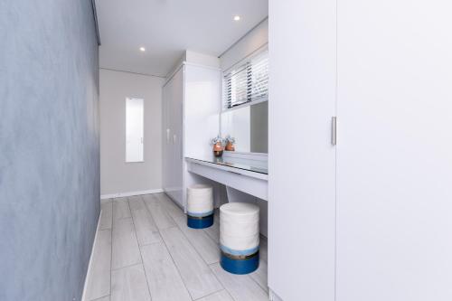 a kitchen with white walls and blue accents at MINT Hotel 84 on Katherine in Johannesburg