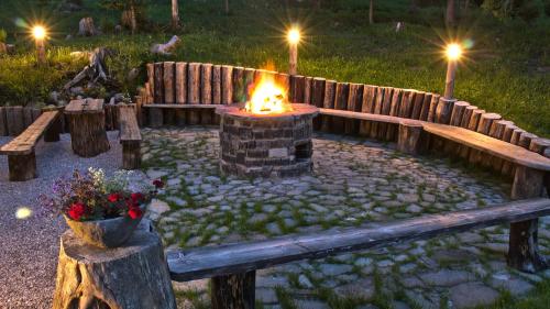 a fire pit in a garden with benches and torches at Chata Baba Yaga in Ždiar