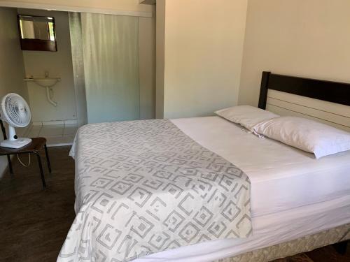 a bedroom with a large bed with a white comforter at Hotel economic eldorado in Sorocaba