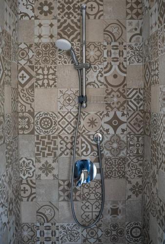 a shower in a bathroom with a tile wall at Villa Amanda in Scorcetoli