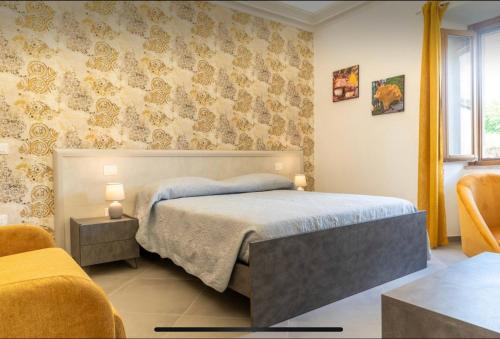 a bedroom with a bed and two chairs at Villa Amanda in Scorcetoli