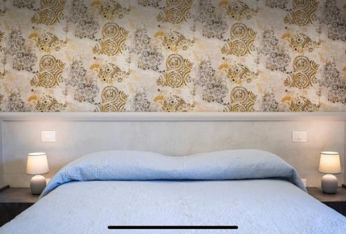 a bedroom with a bed with two lamps and a wall at Villa Amanda in Scorcetoli