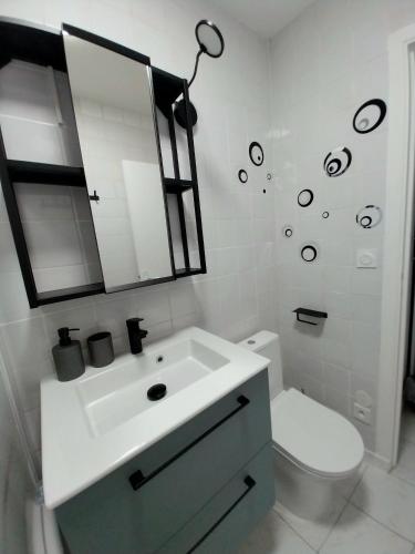 une salle de bain blanche avec un lavabo et des toilettes dans l'établissement Studio lumineux 3 min Gare Houilles - RER A, Ligne L et J, à Houilles