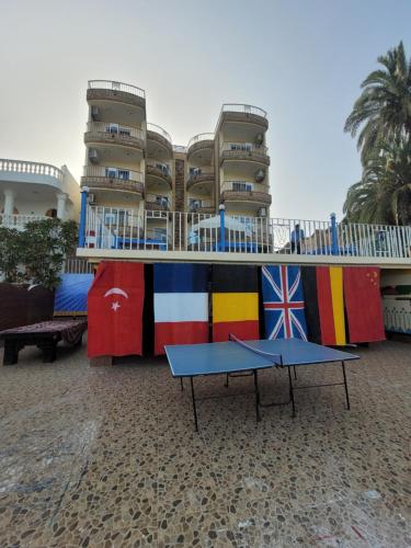 une table avec drapeaux devant un bâtiment dans l'établissement Blue Nile House, à Louxor