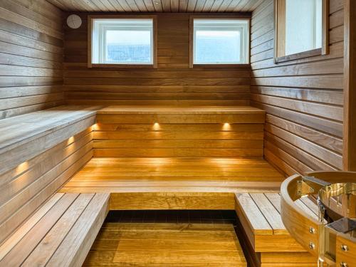 una sauna con paneles de madera y una bañera en Strandnäs Gård en Mariehamn